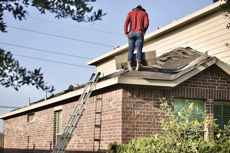 Professional roofer working on a residential roof in West March